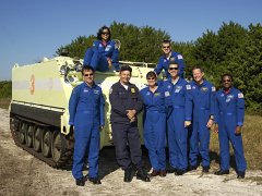The STS-107 crew poses for a group portrait with their instructor beside an M113 armored personnel carrier. NASA photo KSC-02PD-1938.