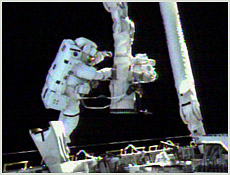STS-108 Mission Specialist Linda Godwin tethers herself to Space Shuttle Endeavour's robotic arm at the start of Monday's space walk. NASA image.
