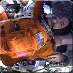 Workers strap Commander Scott Altman (foreground) into his seat in Space Shuttle Columbia's cockpit. Image courtesy of NASA TV.