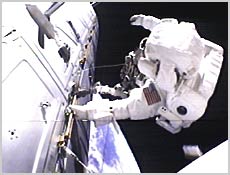 Space walker Robert Curbeam is attached to the U.S. Laboratory with the Earth below. NASA image.