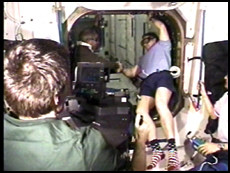 STS-98 Commander Ken Cockrell (left) and Expedition One Commander Bill Shepherd shake hands after the opening of the hatch to the U.S. Destiny Laboratory Module. In the foreground, an Expedition One crewmember films the event. Note the goggles the astronauts wear to protect from possible floating debris. NASA image.